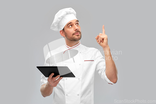 Image of male chef with tablet computer pointing finger up