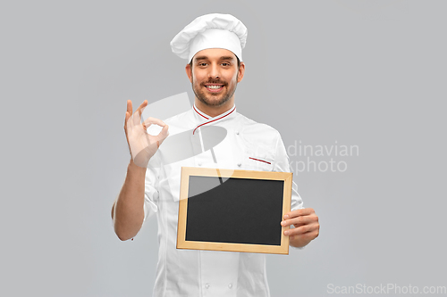 Image of happy smiling male chef showing chalkboard