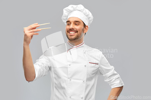 Image of happy smiling male chef with chopsticks