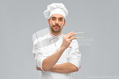 Image of serious male chef with chopsticks