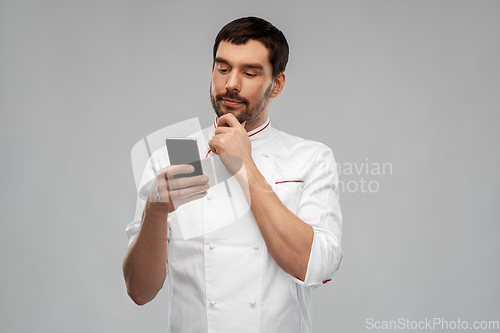 Image of thinking male chef with smartphone