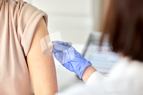 Image of close up of doctor attaching patch to patient