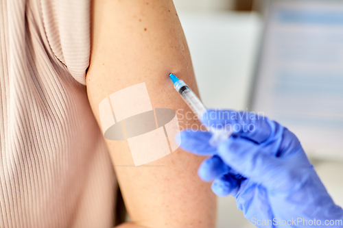 Image of close up of hand with syringe vaccinating patient