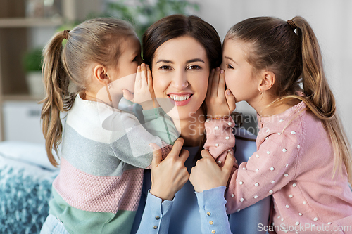 Image of happy mother and daughters gossiping at home