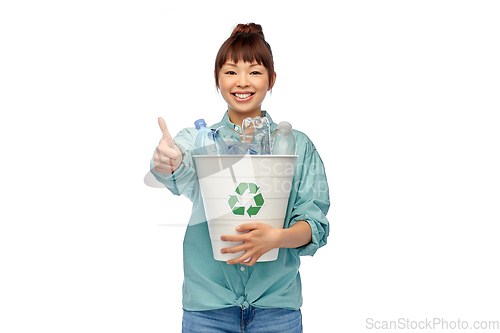 Image of smiling young asian woman sorting plastic waste