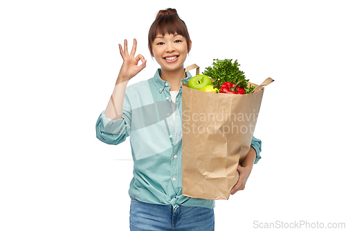 Image of happy asian woman with food in paper shopping bag