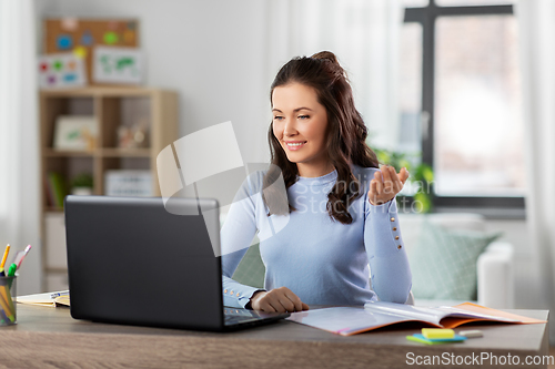 Image of teacher with laptop having online class at home