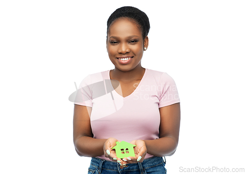 Image of smiling african american woman holding green house