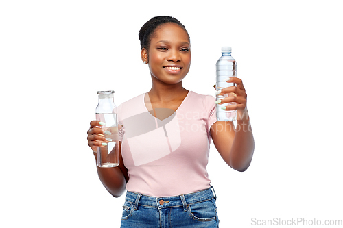 Image of happy woman with plastic and glass bottle of water