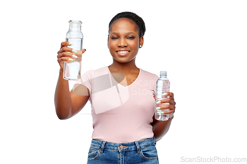 Image of happy woman with plastic and glass bottle of water