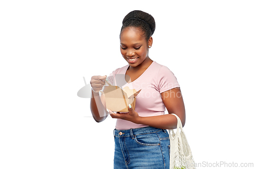 Image of happy woman with reusable string bag eating wok