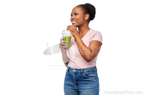 Image of happy african american woman drinking green juice