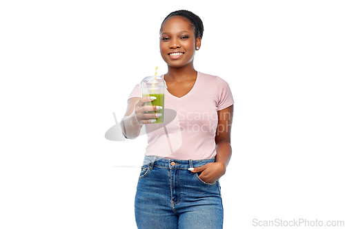 Image of happy african american woman drinking green juice