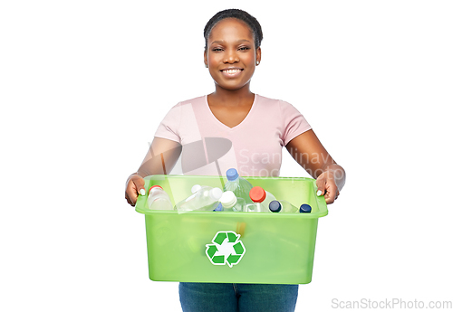 Image of smiling young asian woman sorting plastic waste