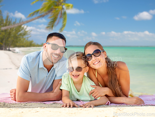 Image of happy family lying over tropical beach background