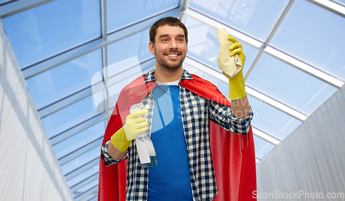 Image of smiling man in superhero cape with rag and cleaner