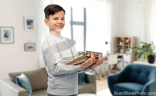 Image of smiling boy with magazines sorting paper waste