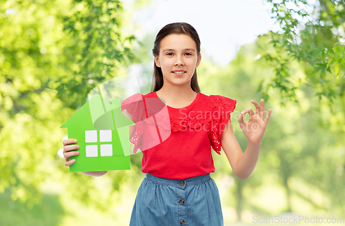 Image of happy little girl with green house icon showing ok