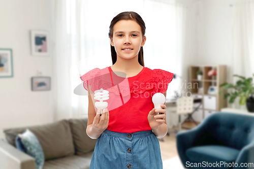 Image of smiling girl comparing different light bulbs