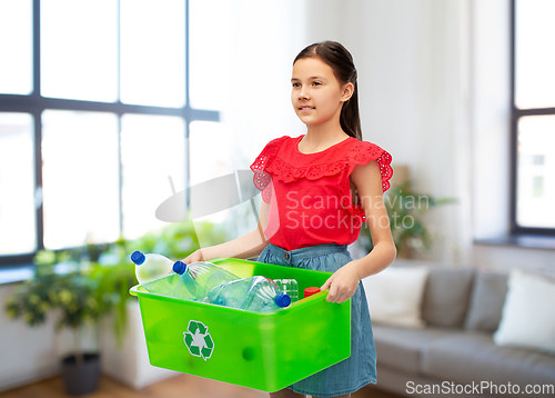 Image of smiling girl sorting plastic waste at home