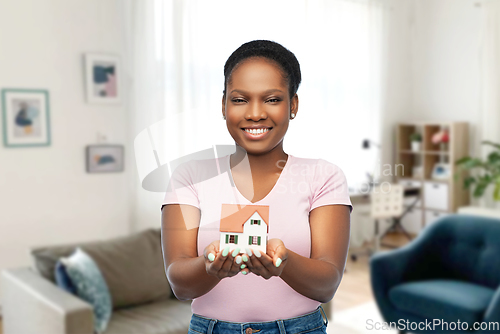 Image of smiling african american woman holding house model