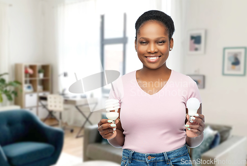 Image of african american woman holding lighting bulbs