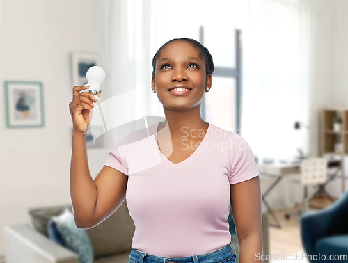 Image of african american woman holding lighting bulb