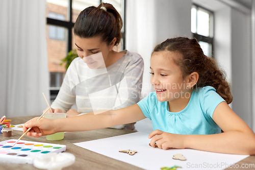 Image of happy mother with little daughter drawing at home