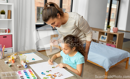 Image of mother with little daughter drawing at home