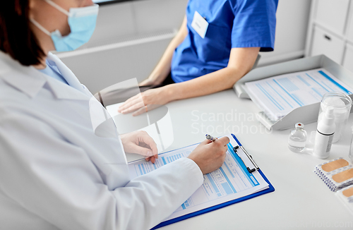 Image of doctor with clipboard and nurse at hospital