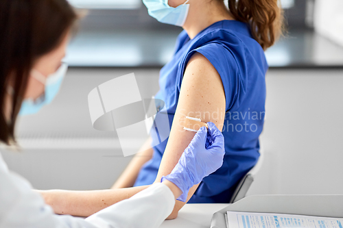 Image of doctor attaching patch to medical worker