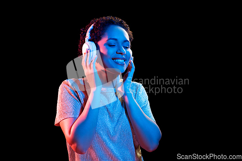 Image of woman in headphones listening to music and dancing