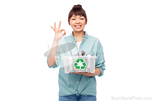 Image of smiling young asian woman sorting metallic waste