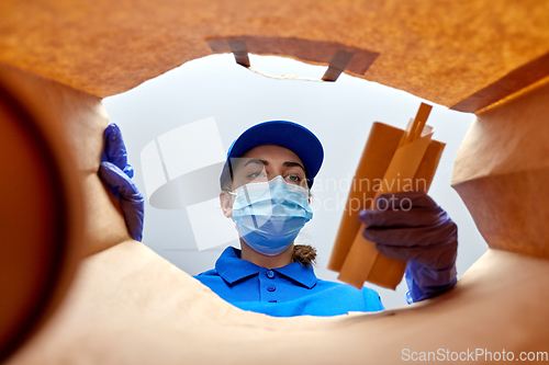 Image of delivery girl in gloves and mask with food in bag