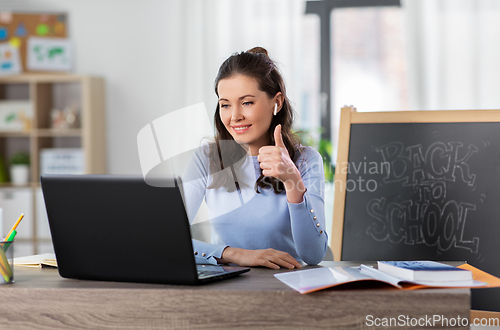 Image of teacher with laptop having online class at home