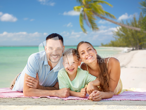 Image of happy family lying over tropical beach background