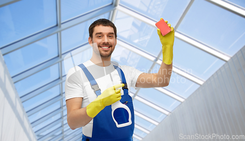 Image of male cleaner cleaning with sponge and detergent