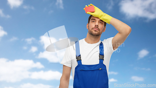 Image of tired male cleaner with sponge