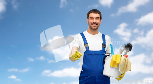 Image of male cleaner in overall with cleaning supplies