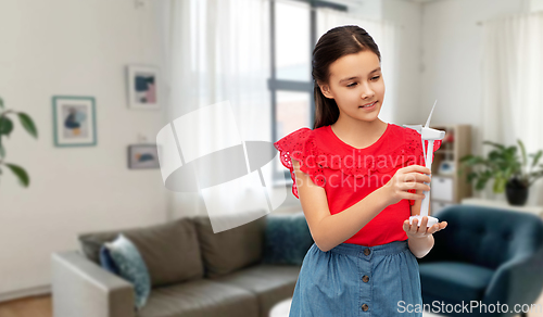 Image of smiling girl with toy wind turbine at home