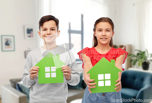 Image of smiling little girl and boy holding green houses