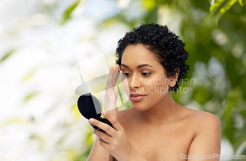 Image of african american woman looking to mirror