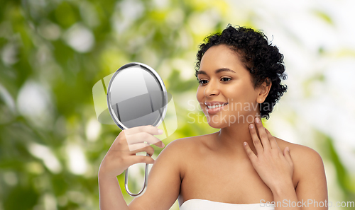 Image of smiling african american woman looking to mirror