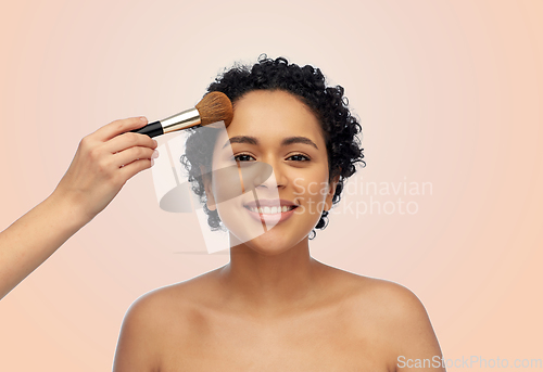 Image of happy woman and hand of make up artist with brush