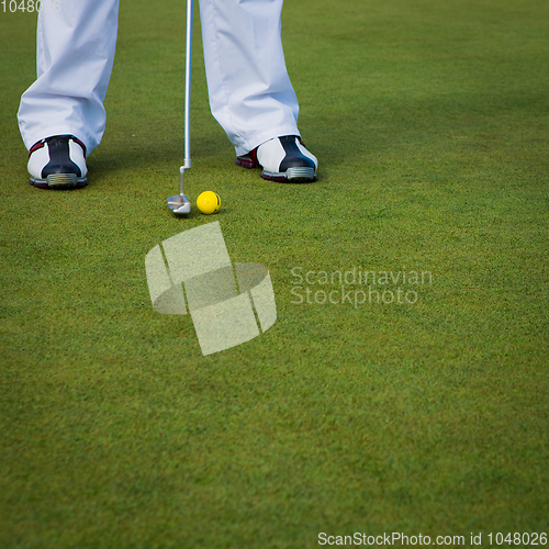 Image of Playing golf. Golf club and ball. Preparing to shot