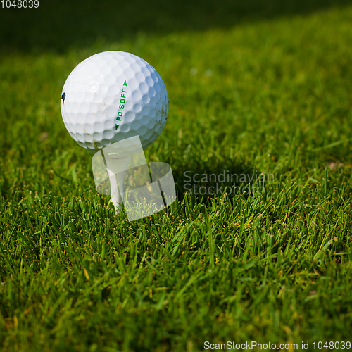 Image of Golf ball on a tee against the golf course with copy space