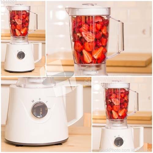 Image of fresh strawberries in white Blender on a wooden table