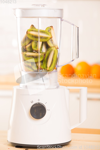 Image of White blender with Kiwi on a wooden table