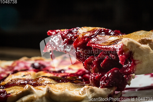 Image of Tasty homemade pie with cherries on table close up