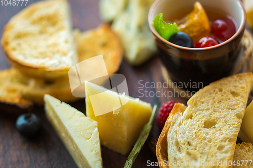 Image of Assorted cheese on a wooden board.